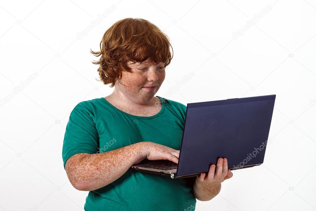 Freckled red-hair boy with laptop.