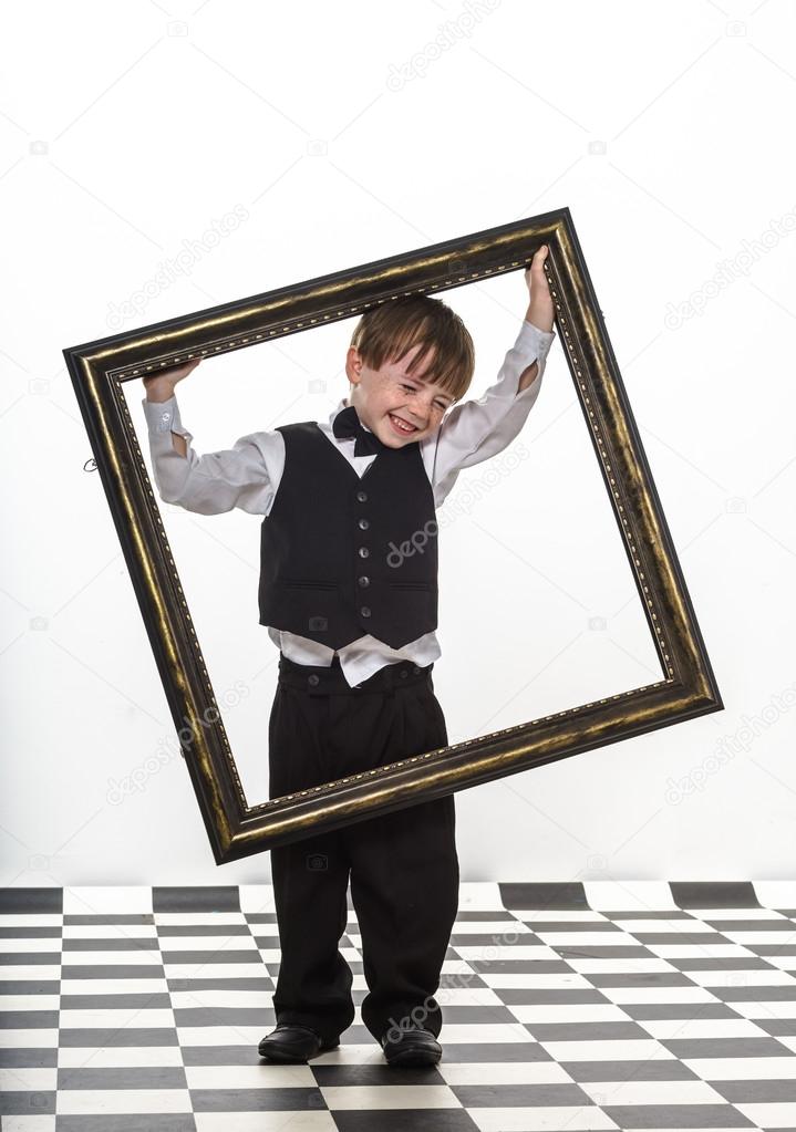 Freckled red-hair little boy with big picture frame.
