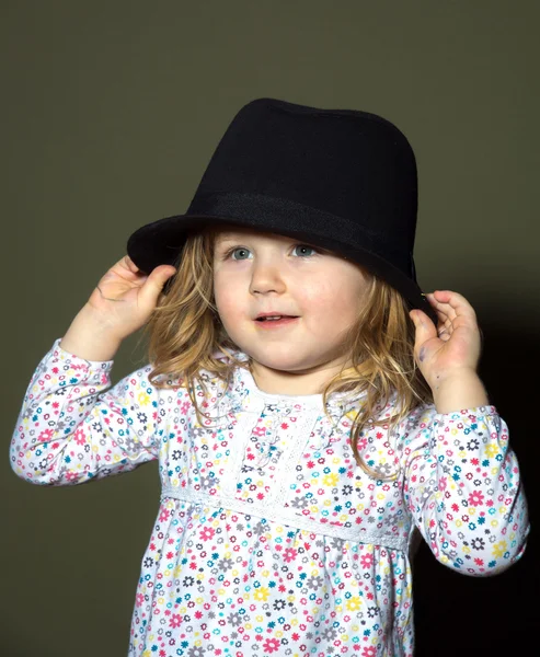 Cute little girl playing with hat — Stock Photo, Image