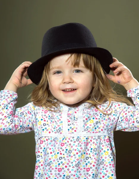 Χαριτωμένο μικρό κορίτσι παίζει με καπέλο — Φωτογραφία Αρχείου