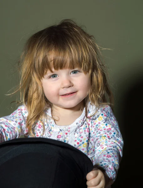 Carino bambina che gioca con il cappello — Foto Stock