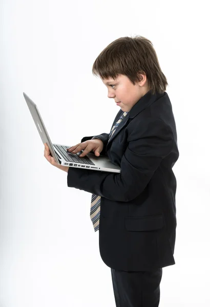 Beyaz dizüstü bilgisayarınızda çalışan bir genç çocuk — Stok fotoğraf
