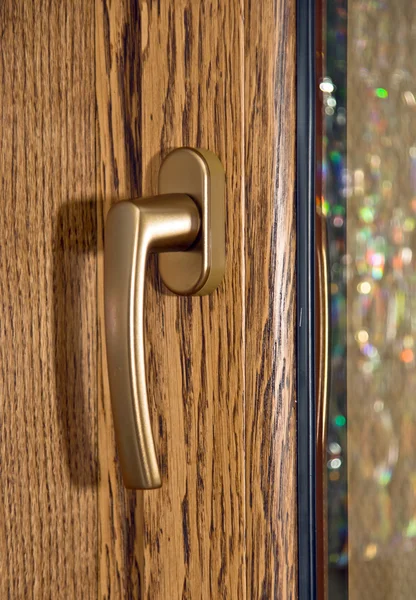 Gold window handle on oak laminated fiberglass window — Stock Photo, Image