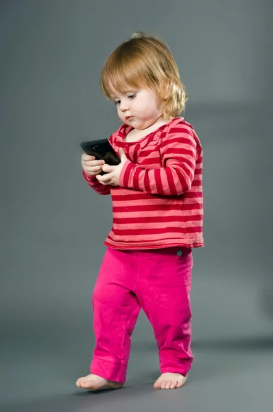 Söt liten flicka med mobiltelefon — Stockfoto