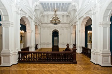 Grand hall in old majestic palace with oak staircase clipart