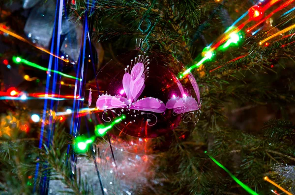 Kleurrijke stralen van kerstverlichting op kerstboom — Stockfoto