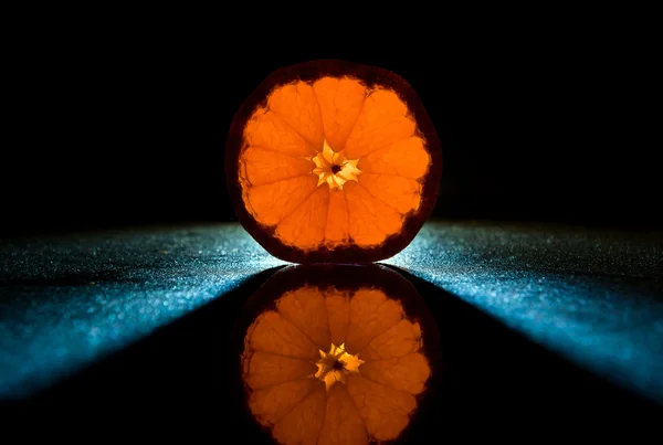 Bright orange natural tangerine on black mirror background — Stock Photo, Image
