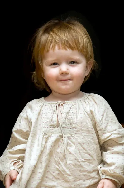 Rindo pequeno bebê em vestido caseiro no fundo preto — Fotografia de Stock