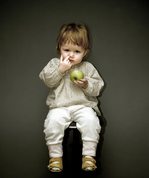 Bayi kecil dengan apel hijau memilih hidung — Stok Foto