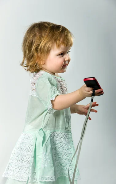 Menina bonito com telefone móvel no fundo branco — Fotografia de Stock