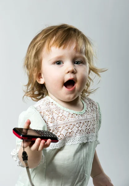 Schattig klein meisje met mobiele telefoon op witte achtergrond — Stockfoto
