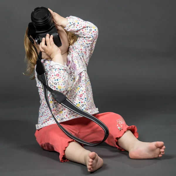 Маленький ребенок с зеркальной фотокамерой — стоковое фото