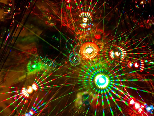 Colorful beams of xmas lights on christmas tree — Stock Photo, Image