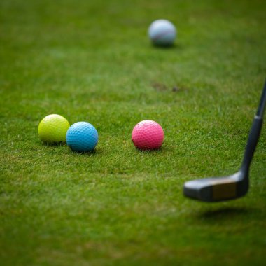 Yeşil çimlerin üzerinde çok renkli golf topları. Golf Kulübü. Spor ve eğlence sektörü. Yaz.