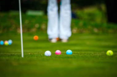 Yeşil çimlerin üzerinde çok renkli golf topları. Golf Kulübü. Spor ve eğlence sektörü. Yaz.