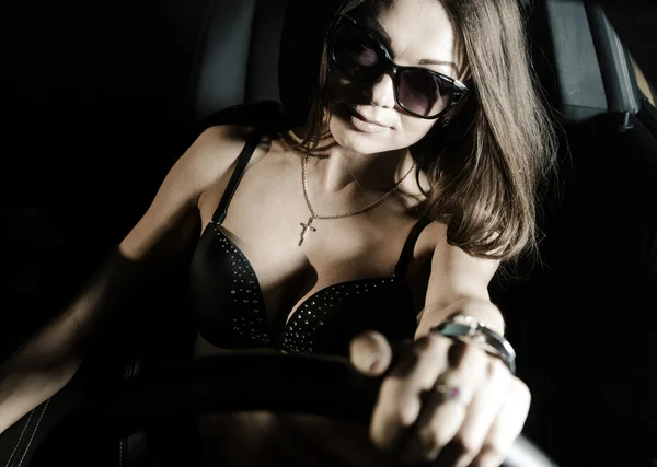 Sexy glamour girl sitting in a car — Stock Photo, Image