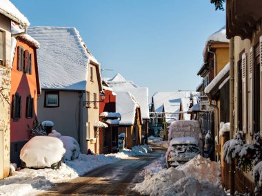 Güneşli kış günü. Karla kaplı evlerin çatıları. Alsace 'deki köy. Fransa.