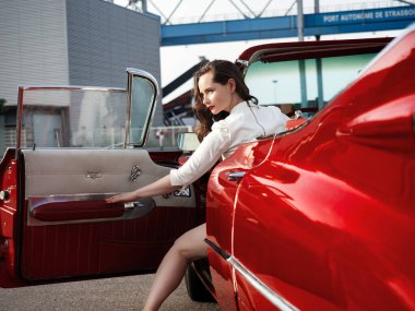 60 'lı yaşlarda kırmızı bir Cadillac ve güzel bir genç kız. Fransa.