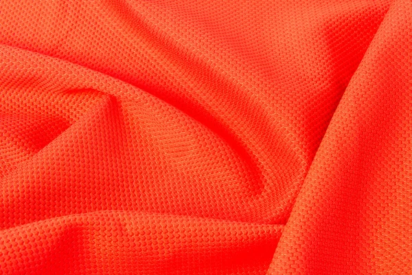 Texture of bright, acid orange cloth with pleats — Stock Photo, Image