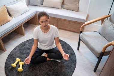Zihnini sakinleştirmek için meditasyon yapan canlı bir kız ve evde rahatlamak için boş vakitleri var..