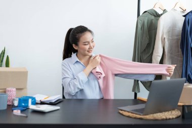 Canlı alışveriş kavramı. Bir kadın tüccar ürünün büyüklüğünü online müşterilere gösteriyor..
