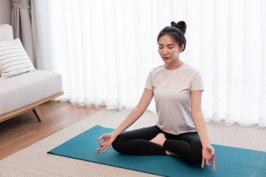 Üretken aktivite kavramı sakin bir kızın oturma odasındaki huzurlu atmosferde tek başına meditasyon yapmaya odaklanması..