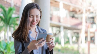 Çalışan kadın konsepti bir fincan kahve tutan genç bir bayan yönetici ve video aracılığıyla iş arkadaşıyla iletişim.