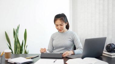 Ofis işi konsepti. Bir kadın memur, bir evrak işi için tabletini kullanıyor..