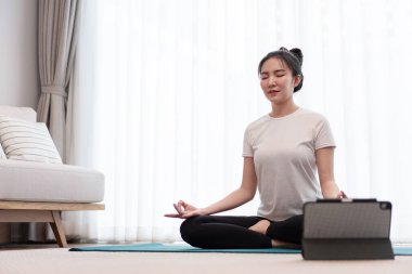 Üretken aktivite kavramı sakin bir kızın oturma odasındaki huzurlu atmosferde tek başına meditasyon yapmaya odaklanması..