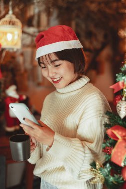 Kız akıllı telefon kullanır ve Noel tatilinin tadını çıkarır, yeni yıl kutlama konsepti.