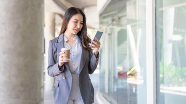 Çalışan kadın konsepti. Video konferansına katılan ve elinde kahve tutan genç bir bayan yönetici..