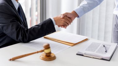 Hukuk kavramı. Beyaz gömlek giyen avukatın yardımcısı ve işini iyi yaptığı için elini sıkan iş adamı..