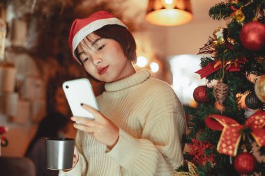 Kız akıllı telefon kullanır ve Noel tatilinin tadını çıkarır, yeni yıl kutlama konsepti.