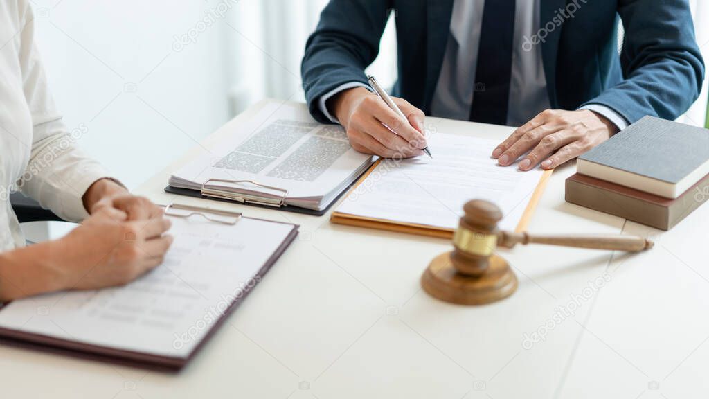 law concept The legal practitioner reading an official document that his advisee, the man in white long sleeved shirt hand to him and writing the signature on it.
