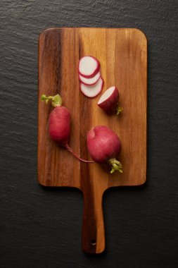 Sebze konsepti. İki pancar kökü ve arka plandaki kesim tahtasına konmuş pancar dilimleri..