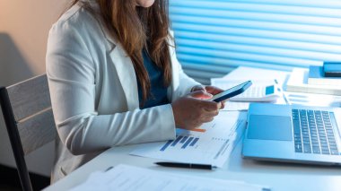 Ofiste geç saatlere kadar çalışan ve telefonuna mesaj atan beyaz ceketli kadın ofis çalışanı hariç..