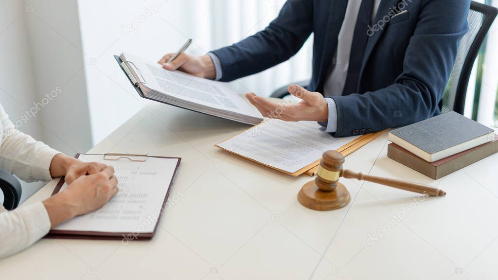 law concept The attorney holding the paper and having a law inspection about the contract of the company that the offer with his helper.