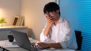 Çalışma Konsepti Ofiste oturan ve masasında esneyen çalışan.