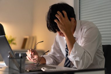 Fazla mesai. Masasında oturan, gözlüğünü çıkaran ve çalışırken kafasını tutan adam hariç..