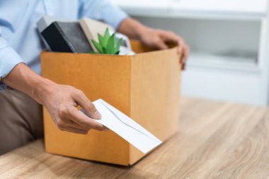 İstifa. Ayakta duran erkek memurun kutusunu masaya bırakıp beyaz mektubu birine teslim etmesi..