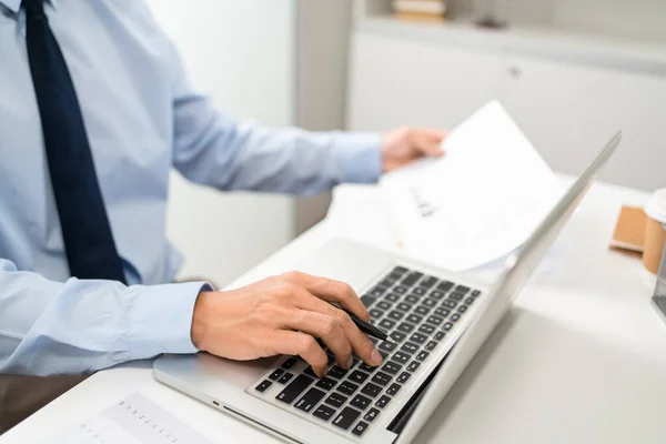 일하는 사람은 책상에서 컴퓨터 왼손으로 문서를 오른손으로 사람을 — 스톡 사진