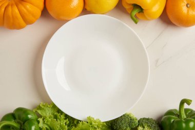 Sebze konsepti lekesiz beyaz tabağın beyaz arka planın ortasına çeşitli sebzelerle birlikte.