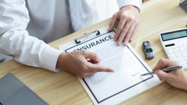 Sigorta konsepti. Erkek satıcı müşterisine araba satın alma sözleşmesini imzalamasını öneriyor..