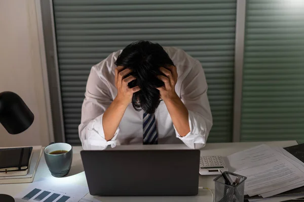 働き過ぎの概念今夜オフィスで働く男は仕事からストレスを受けて頭を抱えている — ストック写真