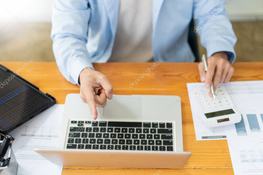 Business analyst concept the accountant using a calculator to estimate the amount of profits.