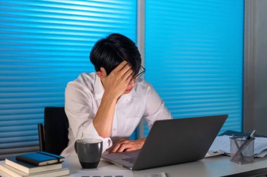 Fazla mesai. Masasında oturan, gözlüğünü çıkaran ve çalışırken kafasını tutan adam hariç..