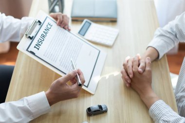 Otomobil satıcısının müşterisinin sözleşmesini vurguladığı sigorta konsepti.