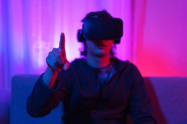 Metaverse teknoloji konsepti, insan VR gözlük takar ve sanal dünyada dokunma deneyimine işaret eder.