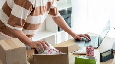 Çevrimiçi alışveriş kavramı ürün tedarikçisi göndermeden önce bilgisayardaki detayları ve paketin içindeki gerçek ürünü kontrol eder..