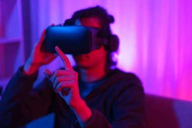 Metaverse teknoloji konsepti, VR gözlükleri tutan ve metaevren deneyimini işaret eden adam..